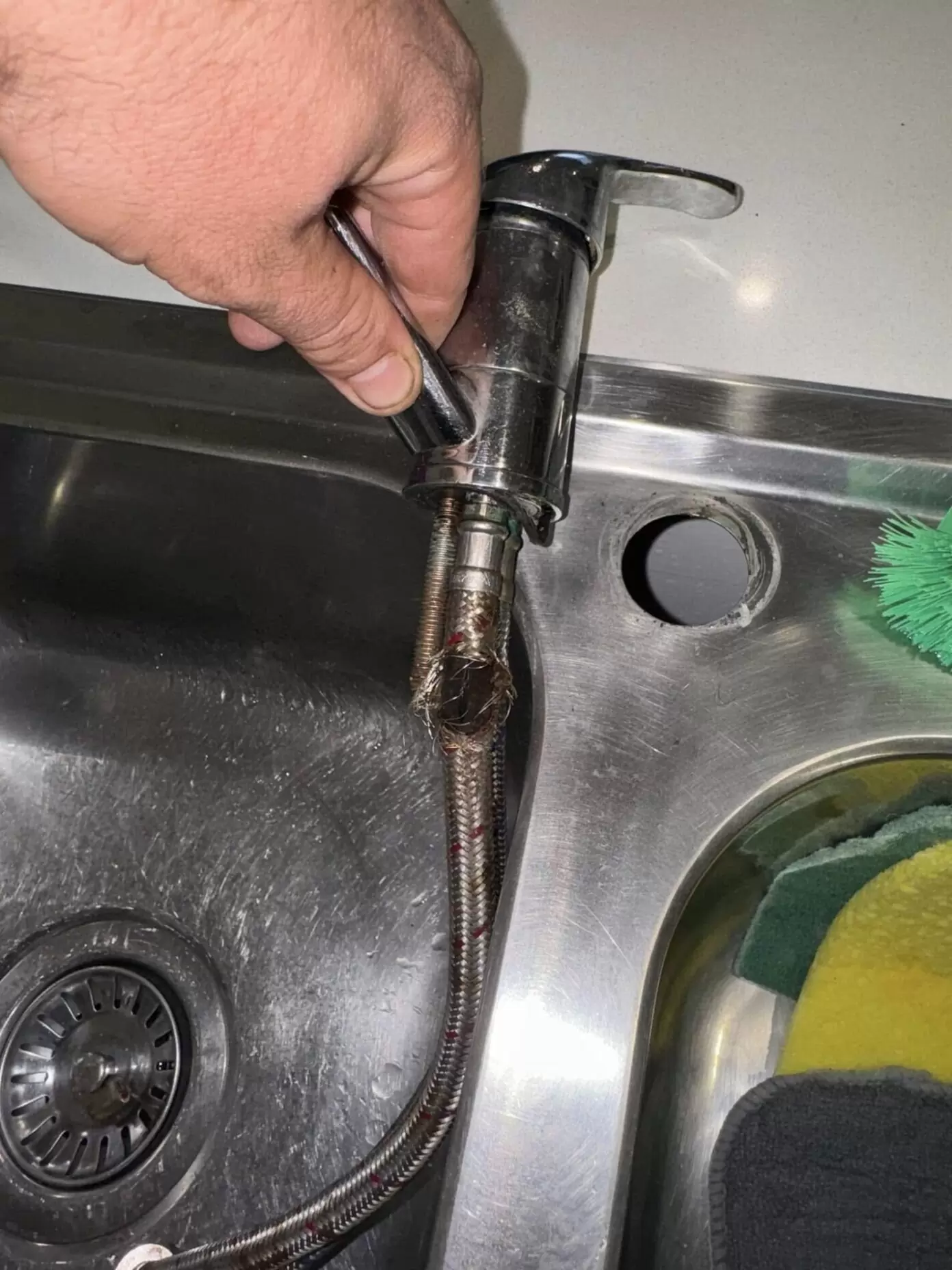 Burst flexi hose under kitchen sink in Pimpama Gold Coast showing split braided water supply line