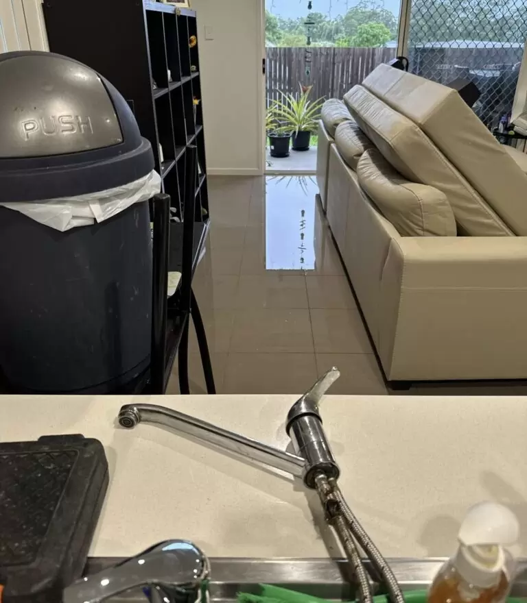 Water flooding across living room floor after burst flexi hose in Pimpama Gold Coast home