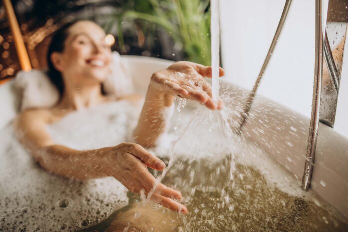 A woman bathes in a tub filled with hot water