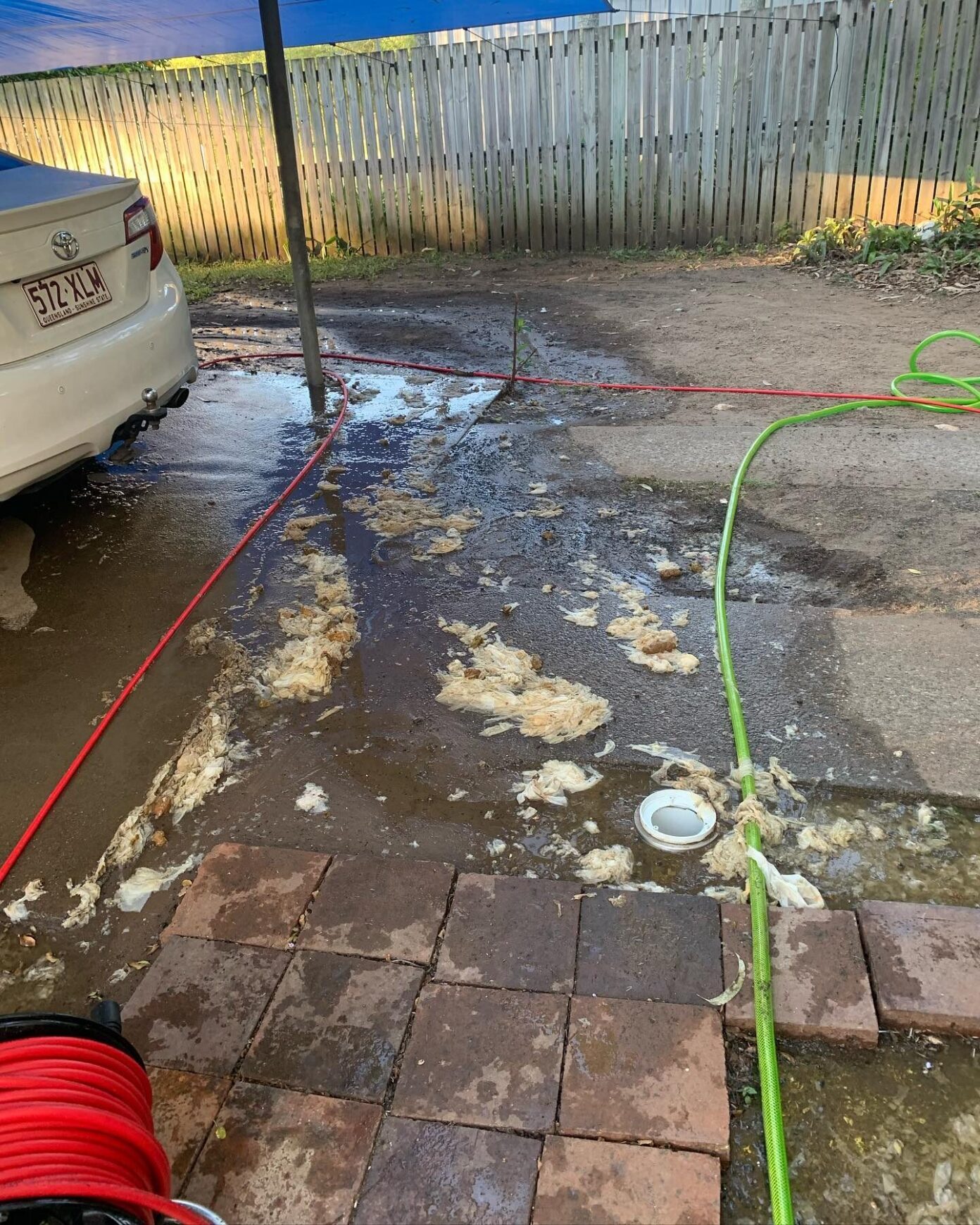 Raw sewage overflowing onto driveway from external drain due to severe blockage
