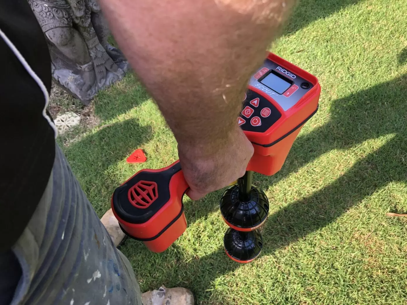 Plumber using electronic locator for underground drain mapping on a Gold Coast property