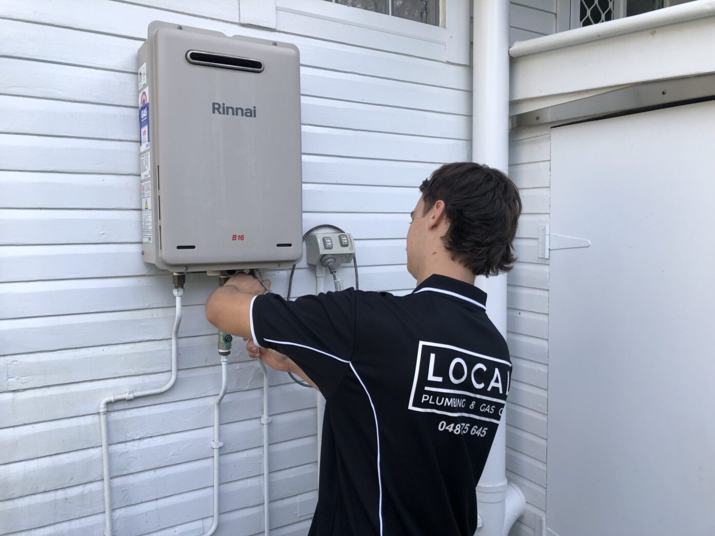Licensed gas plumber repairing a non-compliant gas hot water system in Highland Park, Gold Coast