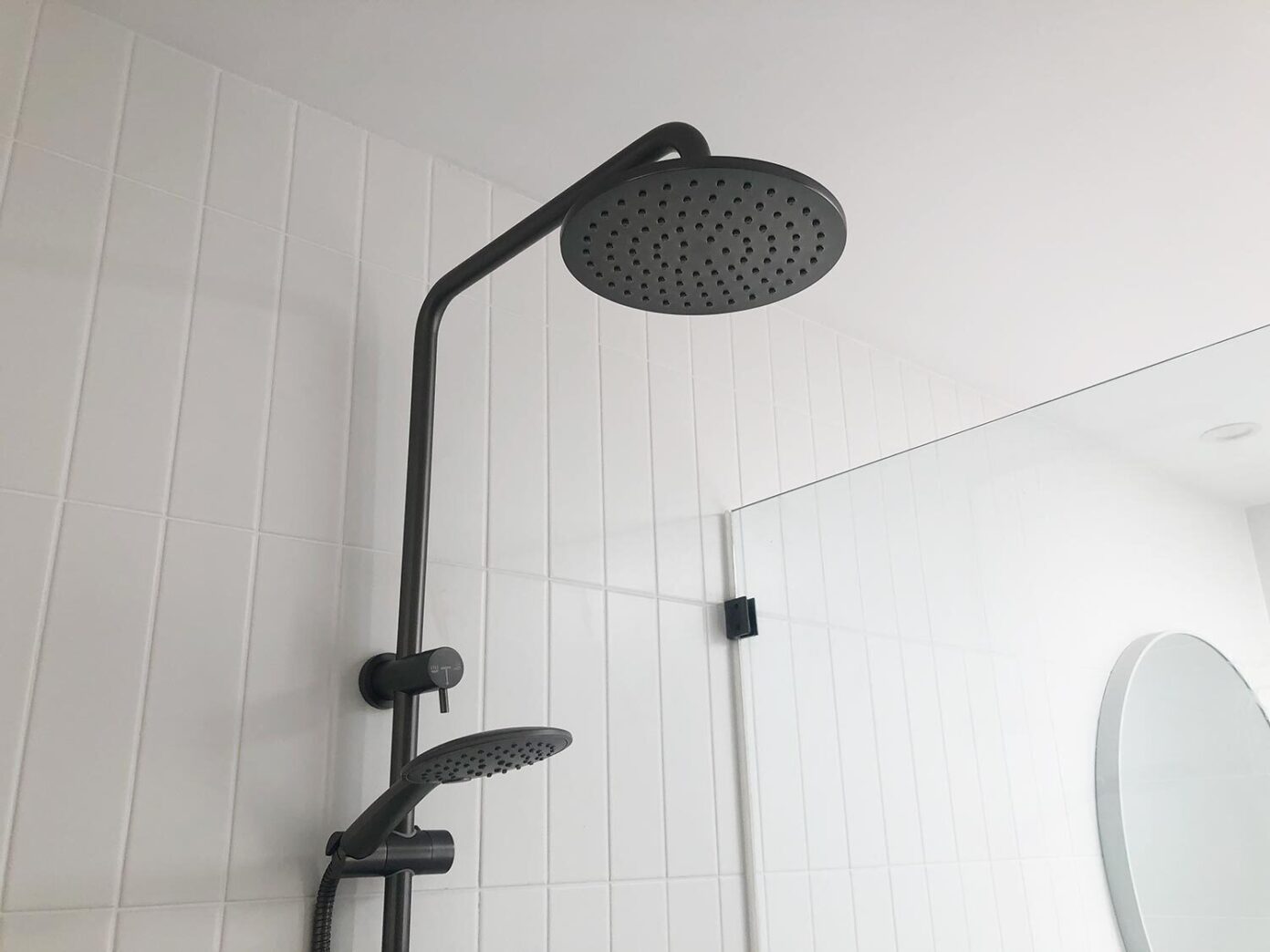 Close-up of dual showerhead system checked for leaks in a Gold Coast bathroom.