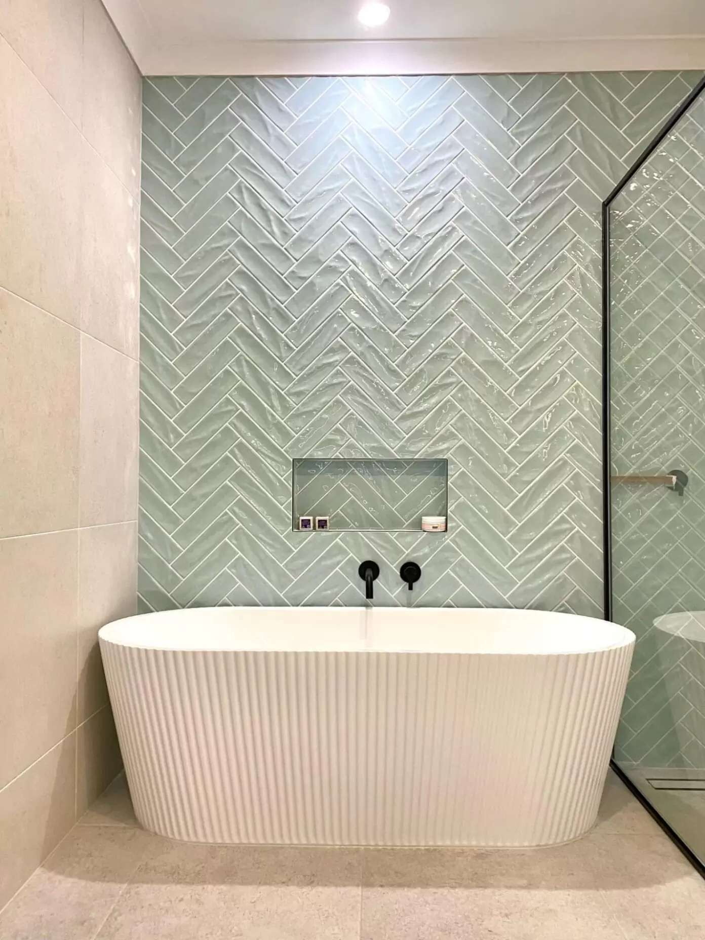 Textured fluted freestanding bath with herringbone feature wall tile in Sovereign Islands