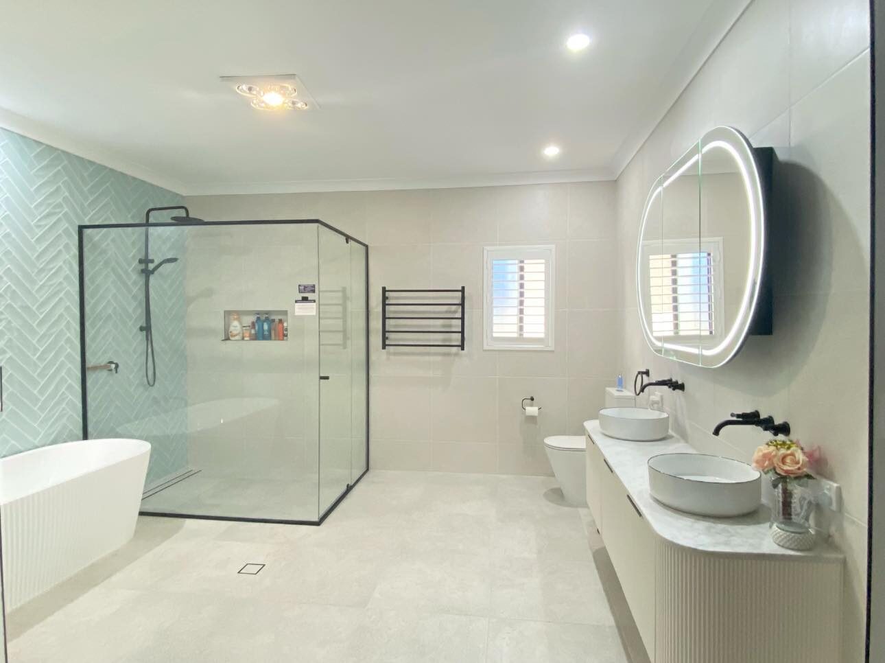 Custom bathroom with feature herringbone tiles and modern bath – Upper Coomera renovation