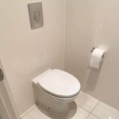 Modern toilet with in-wall cistern and gloss white tiles installed in Biggera Waters