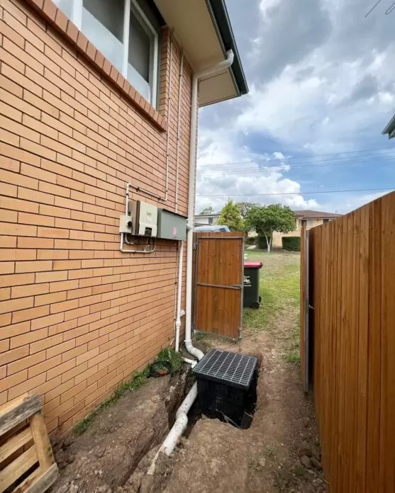 New stormwater drainage pit installed beside house during major plumbing system upgrade in Brisbane.