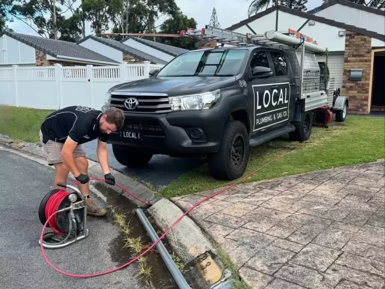 Local Plumbing & Gas Co. drainage plumber clearing blocked stormwater pipe on the Gold Coast roadside