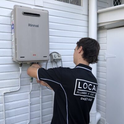Alt tag: Licensed gas plumber repairing Rinnai gas hot water system.