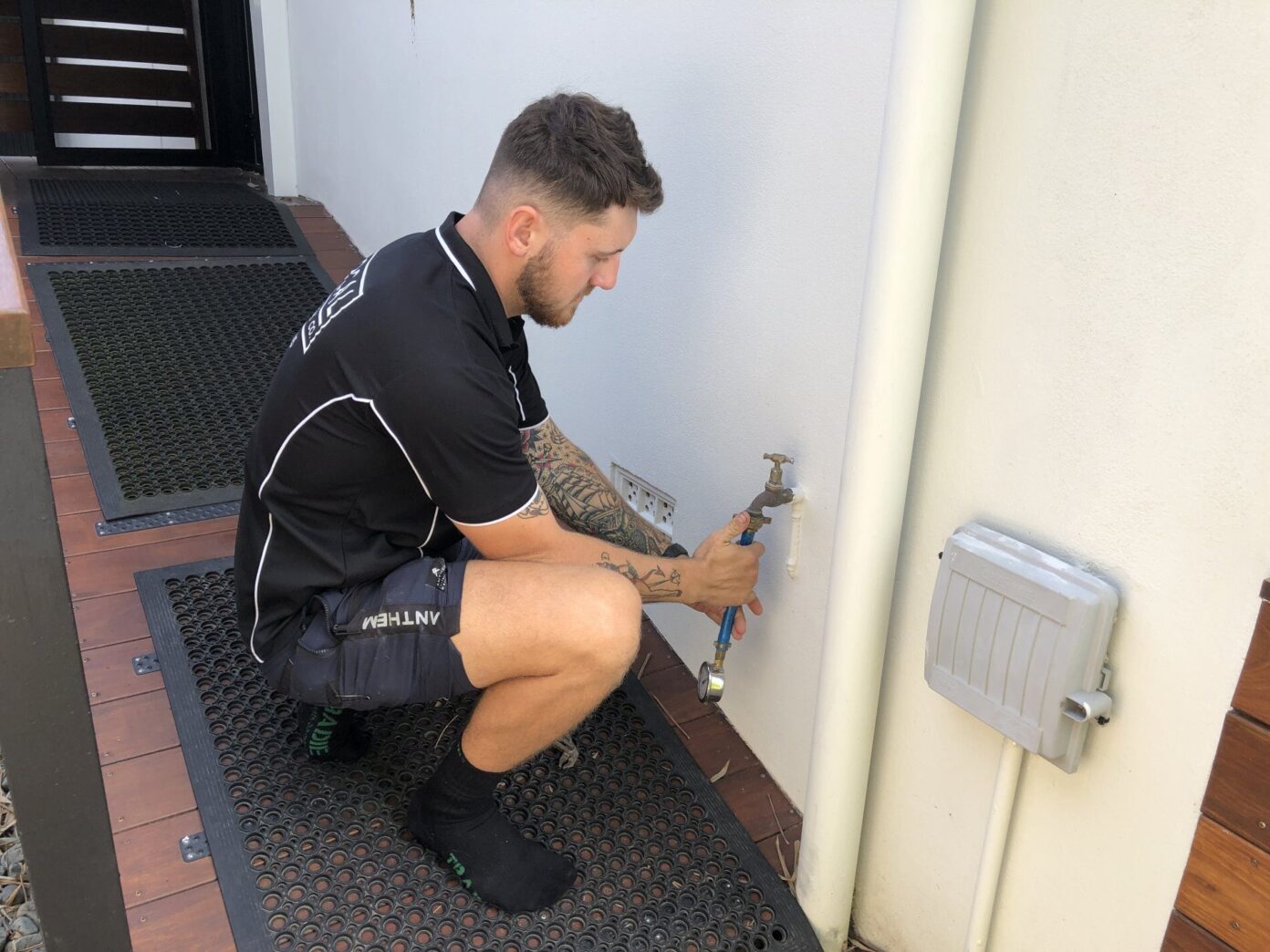Plumber servicing an outdoor tap at a residential Gold Coast property