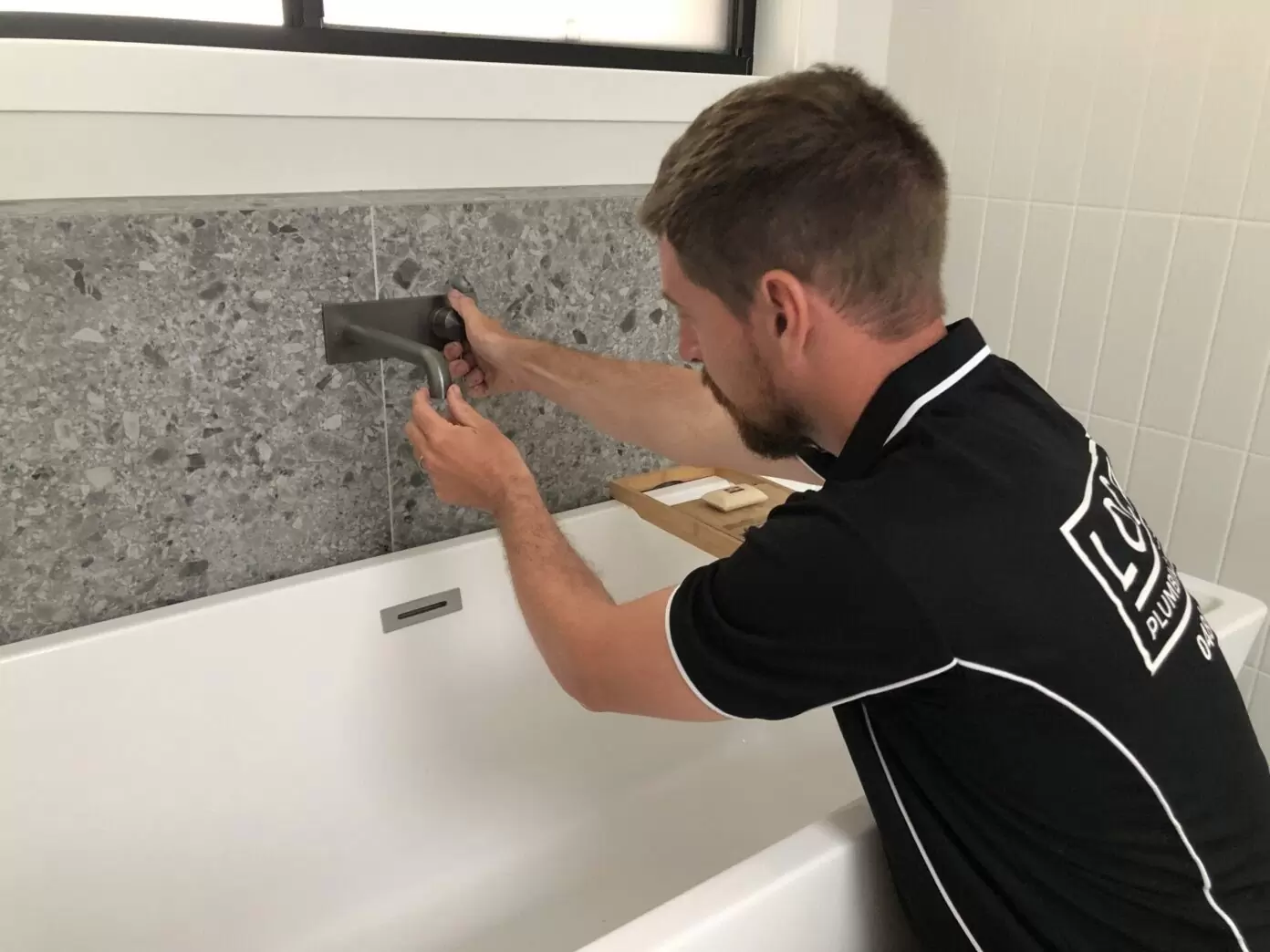 Gold Coast bath plumber installing wall-mounted tap