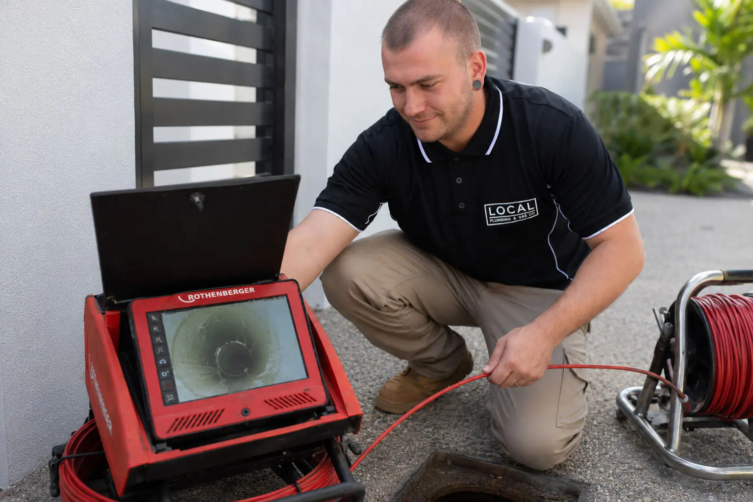 Local Plumbing & Gas Co. plumber viewing CCTV drain inspection footage on a screen during a Gold Coast drain inspection
