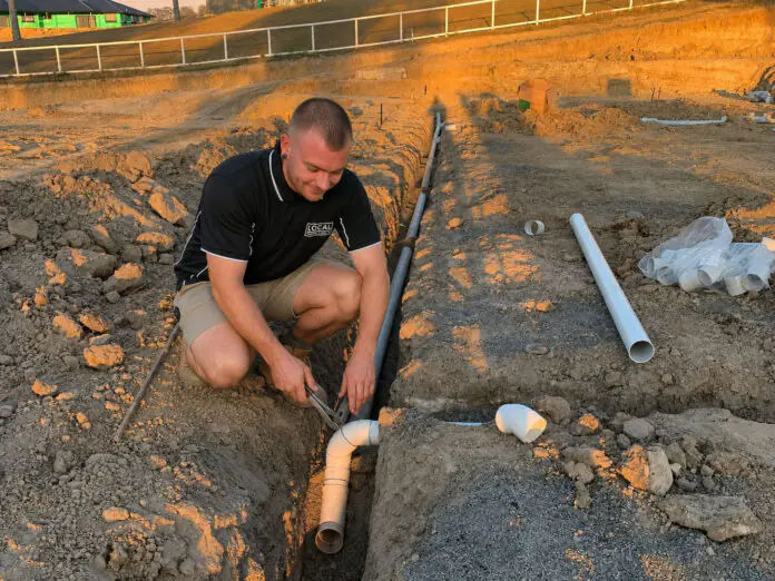 Local Plumbing & Gas Co. plumber completing a new sewer pipe installation on the Gold Coast