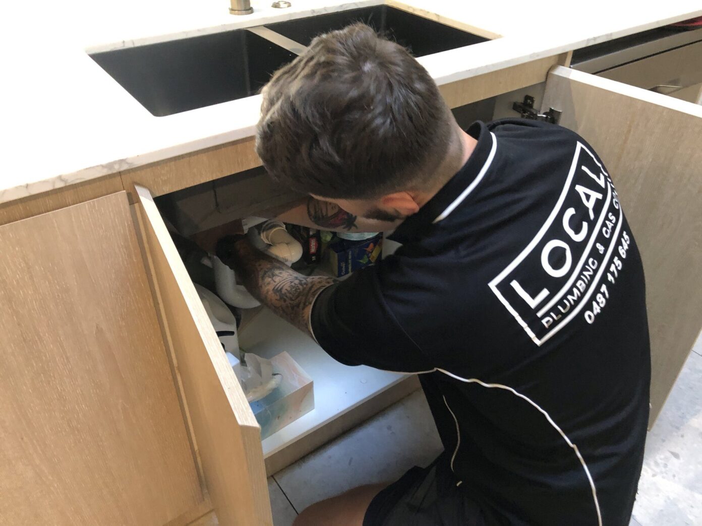 Plumber Repairing Burst Pipe in Kitchen