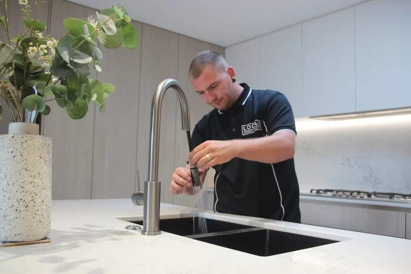 plumber replacing kitchen tap on the gold coast