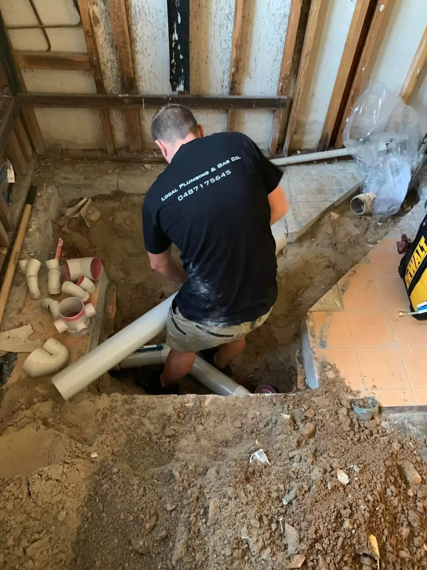 Plumber installing bathroom drainage pipes during bathroom renovation plumbing rough-in on the Gold Coast