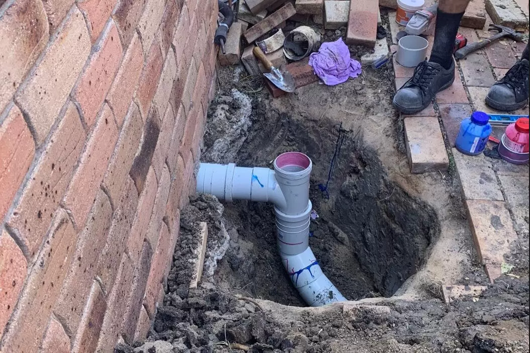 New PVC sewer pipe installed during residential drainage repair
