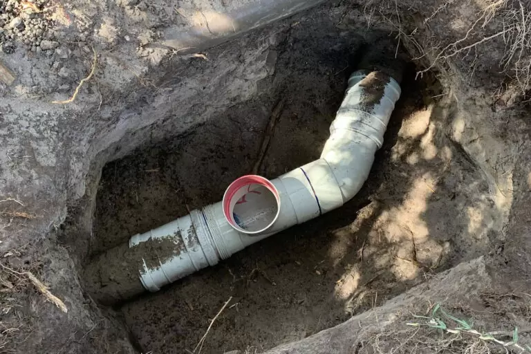 Plumber repairing damaged underground sewer pipe during sewer line repair on the Gold Coast