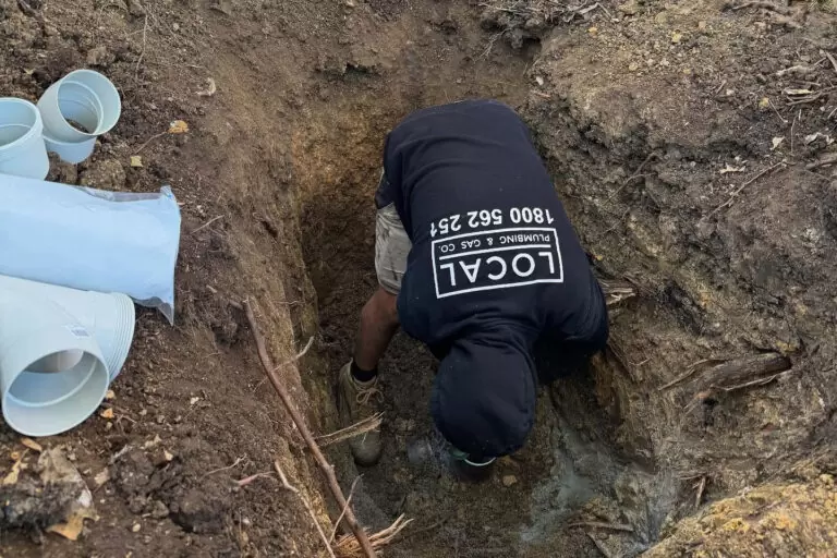 Plumber excavating and repairing a residential sewer line on the Gold Coast