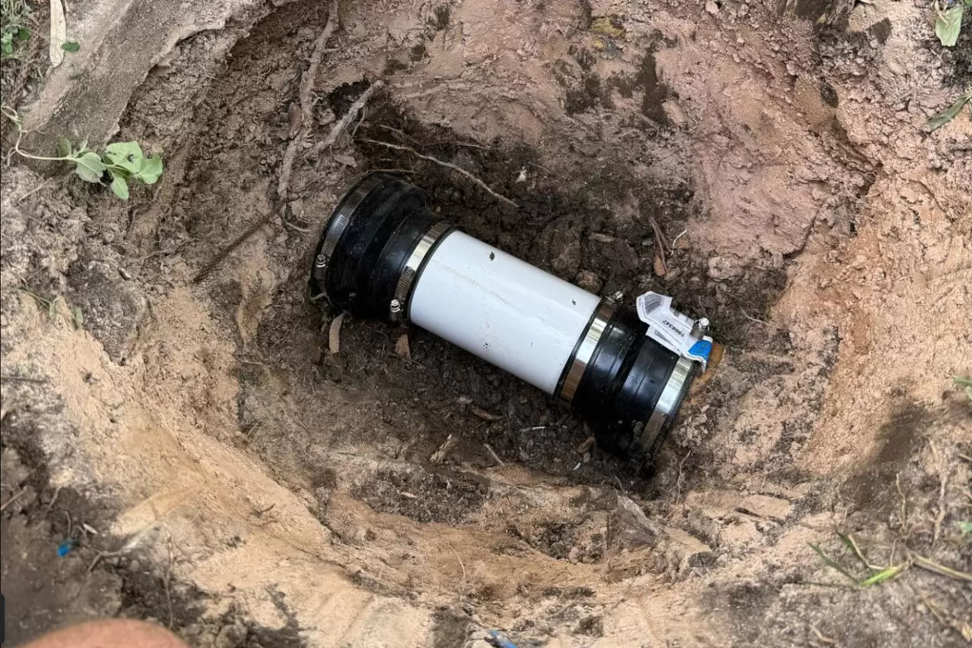 Section repair of an underground sewer pipe using a coupling