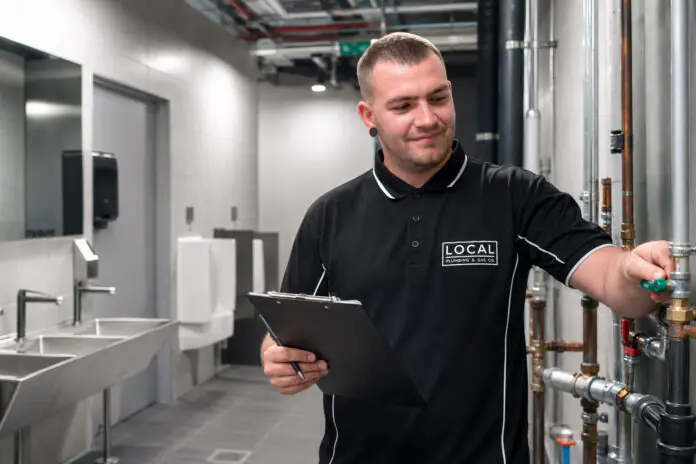 Gold Coast commercial plumber inspecting restroom pipework during scheduled plumbing maintenance