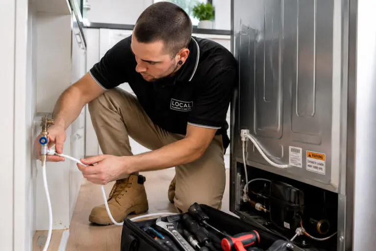 Licensed plumber connecting a dedicated water line and isolation valve to a plumbed fridge