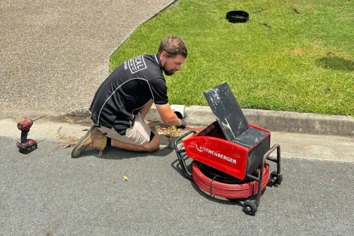 plumber inspecting a blocked drain at a Gold Coast home
