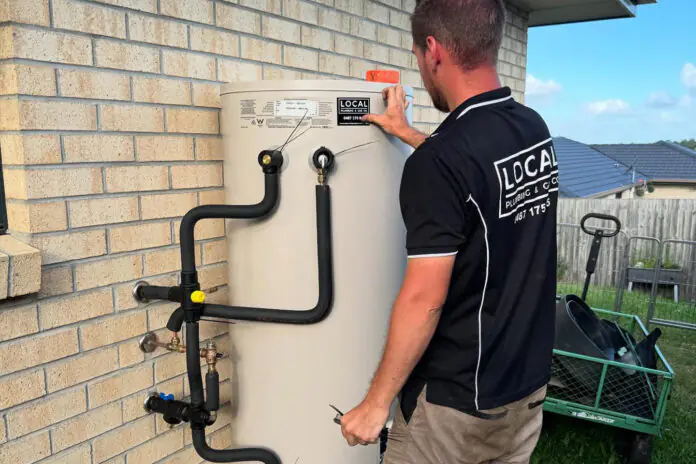 plumber installing new hot water system at a Gold Coast home